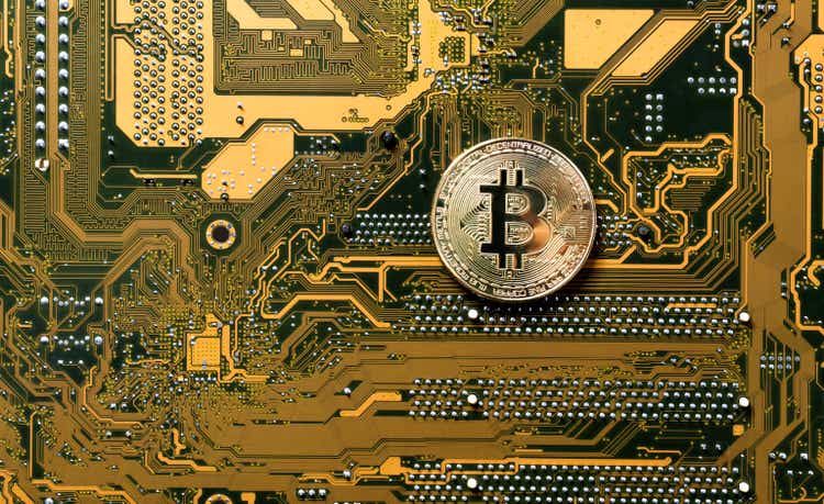 Pièce d'or Bitcoin sur un circuit informatique jaune et noir