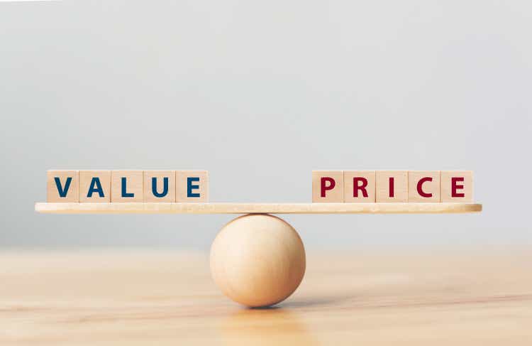 Empty wooden seesaw scale on a wooden ball on a wooden table with the words 