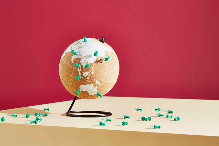 A world globe marked with push pins