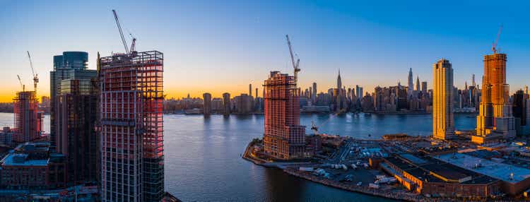 New luxury residential towers" construction on the waterfront of East River in Greenpoint, Brooklyn, and Hunters Point, Queens, around Newtown Creek, with the scenic view of Manhattan skyline. Extra-large high-resolution aerial panorama.