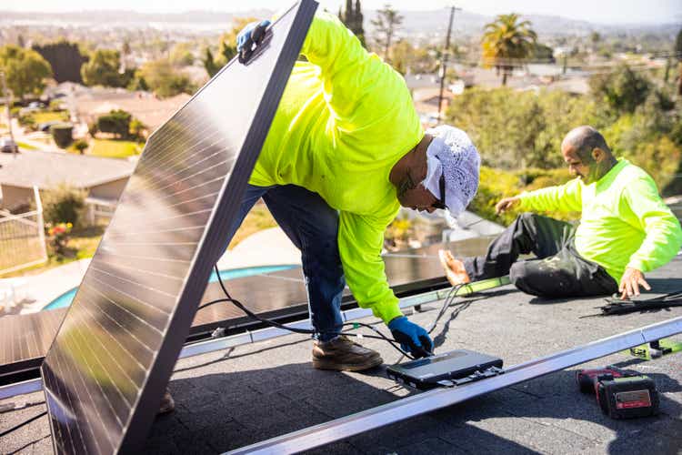 Hispanic Man Connecting Solar Panels to Micro Inverters