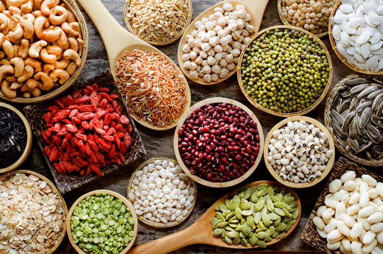 Collection of dry organic colorful cereal and grain seeds in wooden bowl in dark tone, consisted of bean, flax seed, goji berry, rice, peanut, job"s tear, mung, and corn, for healthy food ingredient concept