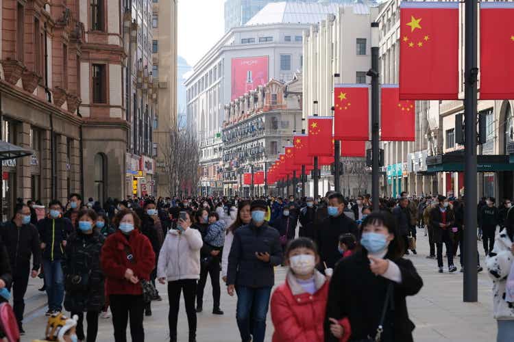 crowded tourists in face mask, walking on Nanjing Road in Shanghai