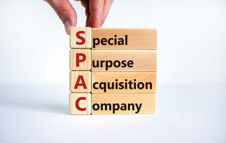 SPAC, the symbol for a special purpose acquisition company.  The businessman holds the cubes and words 