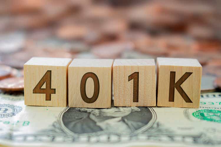 Bloque de madera con el número 401K con algo de dinero alrededor. Concepto: Plan de jubilación en EE.UU.