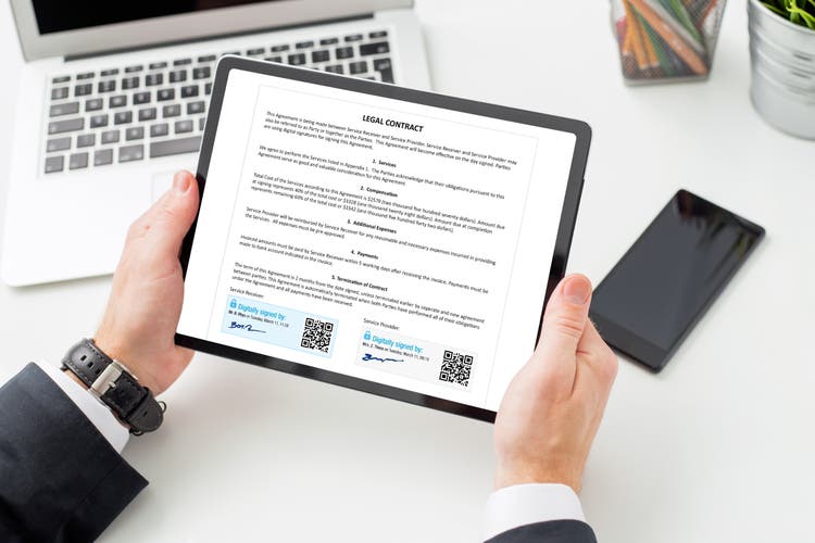 Mens op het werk die juridisch contract ondertekent met behulp van digitale handtekening