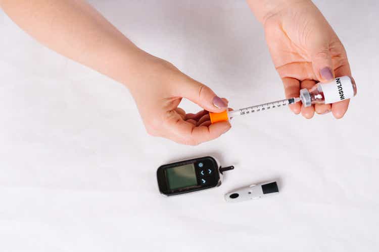 Insulin syringe for administering insulin to diabetic patients on white background. Diabetes treatment, drug addiction concept.