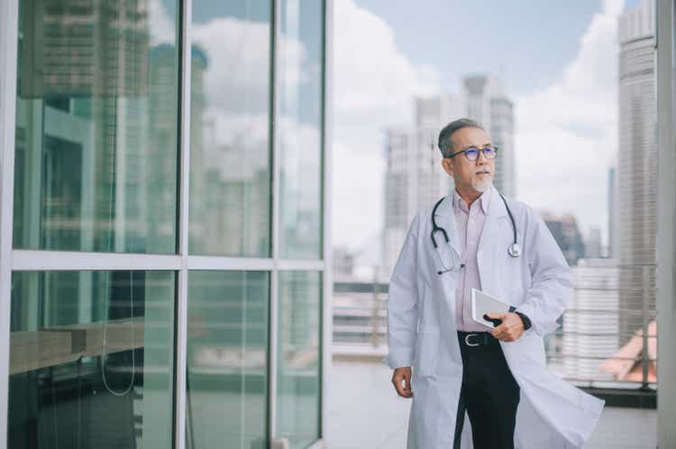 asian chinese male doctor walking towards his office