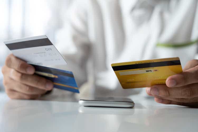 Hände bei der Auswahl einer Kreditkarte