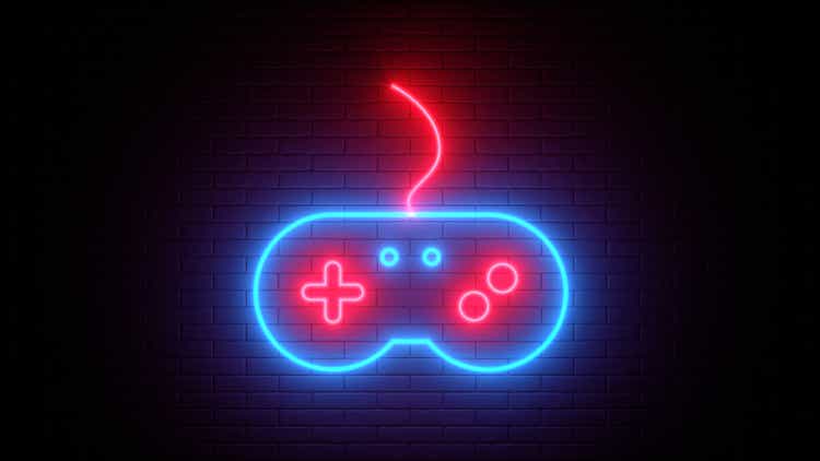 Neon sign on a brick wall. Glowing gamepad icon. Abstract background, spectrum vibrant colors. 3d render illustration.