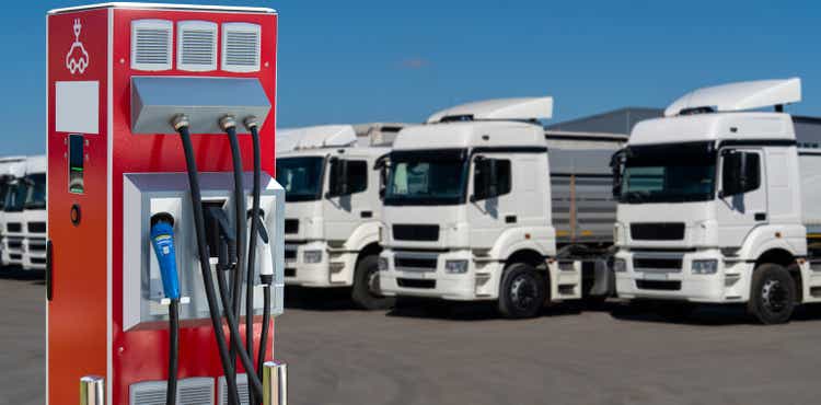 Electric vehicles charging station on a background of a trucks