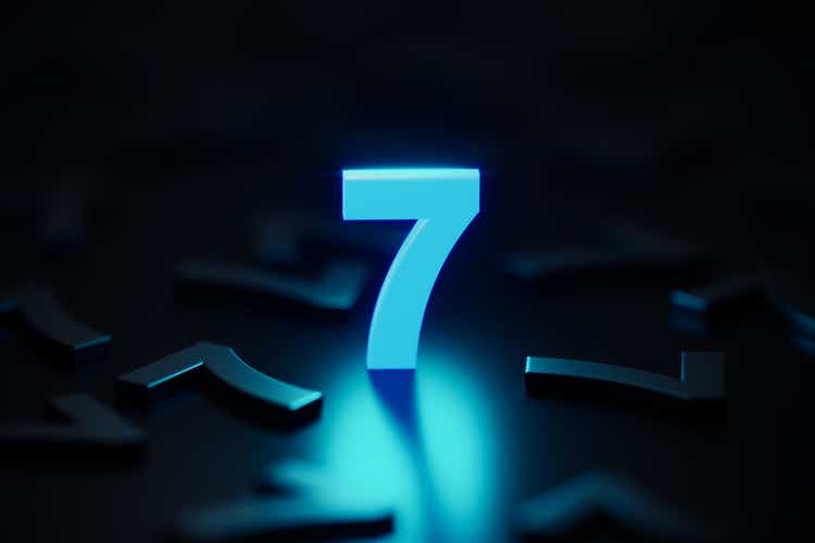 Blue Number Seven Glowing Amid Black Number Sevens On Black Background