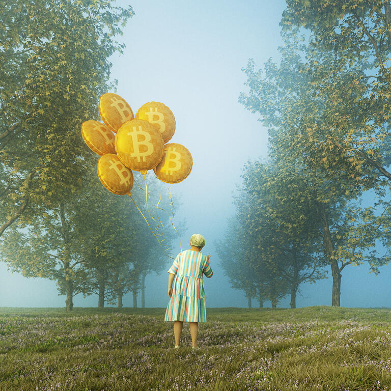 Senior woman holding bitcoin balloons
