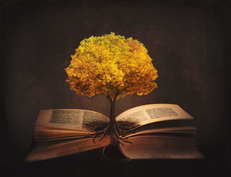 Book of life, knowledge, wisdom - old tree and its roots on open pages of a magic book;