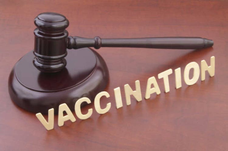 Wooden judge gavel and word vaccination on table.