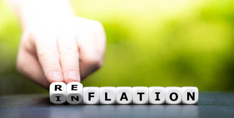 Hand turns dice and changes the word inflation to reflation.