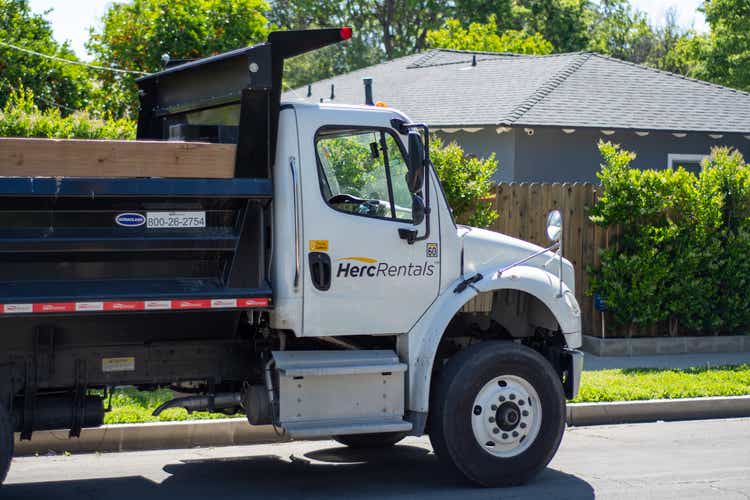 A City of Los Angeles Sanitation department-rented Herc Rentals dump truck at the site of a trash pickup. It was towing a flat-bed trailer.