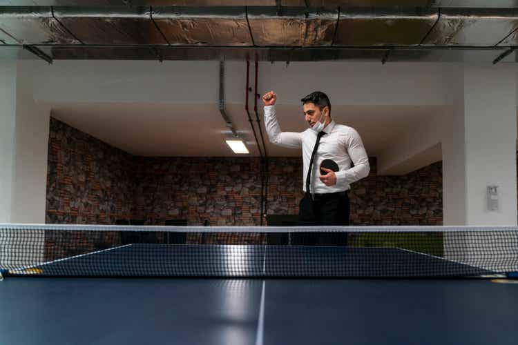 Officer playing table tennis in office building living area