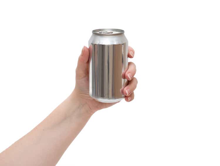 A woman"s hand holds an aluminum can.