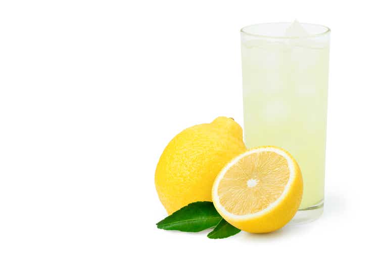 Lemon juice or lemonade with fresh yellow limon fruit and green leaf isolated on white
