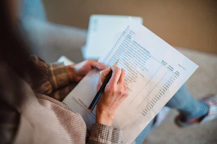 Young woman moved into her new house and checking the list of new flat pack furniture