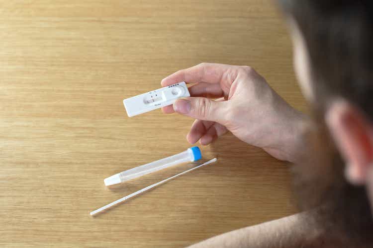 Young man holding a negative covid-19 self test at home, self test kit for Coronavirus top view with copy space