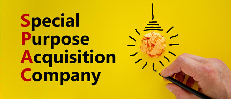 SPAC, special purpose acquisition company symbol. Word "SPAC" on beautiful yellow background, copy space. Businessman hand, light bulb. Business and SPAC, special purpose acquisition company concept.