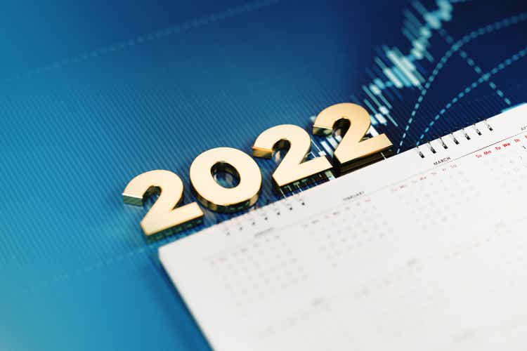 Investment And Financial Planning Concept - 2022 Sitting Over White Calendar On Blue Financial Graph Background