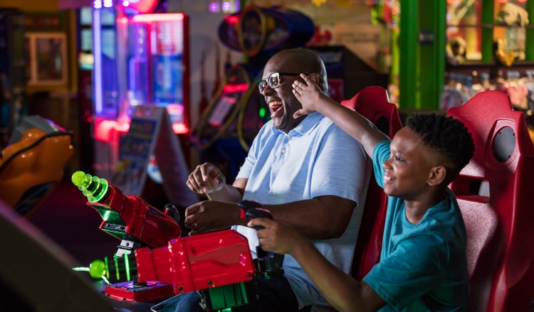 Father and son playing amusement arcade game