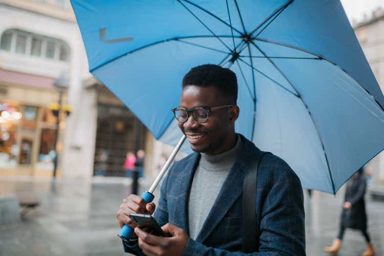 Handsome African American man in the city on a rainy day