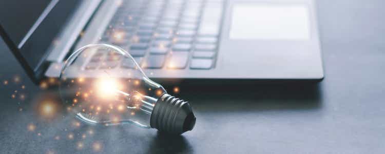 Laptop and bright light bulb.  Knowledge of self-learning or education and business study concept.  Idea of ​​learning online or e-learning from home.