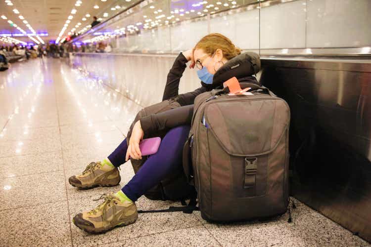Young Female traveller napping as she waits forever at the airport terminal