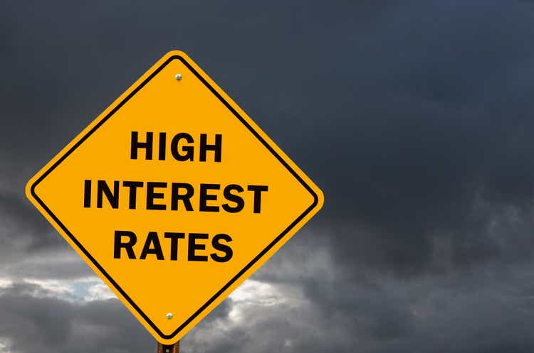 Yellow road sign warning against high interest rates ahead