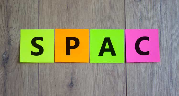 SPAC, special purpose acquisition company symbol. Colored papers with word "SPAC" on beautiful wooden background, copy space. Business and SPAC, special purpose acquisition company concept.