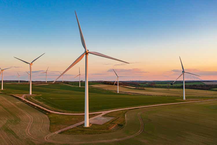 Drone view of a wind farm at sunset. Multiple wind turbines