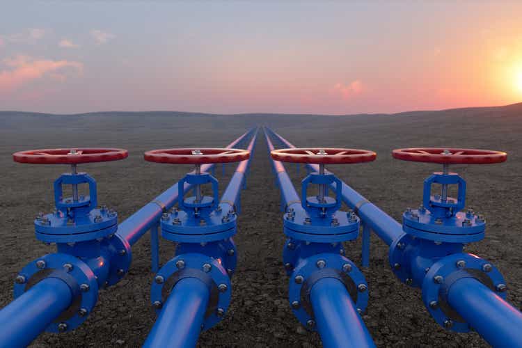 Oil or gas transportation with blue gas line or pipeline valves on ground and sunrise background