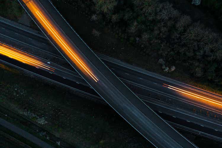 Drone view of cars moving in different directions at night