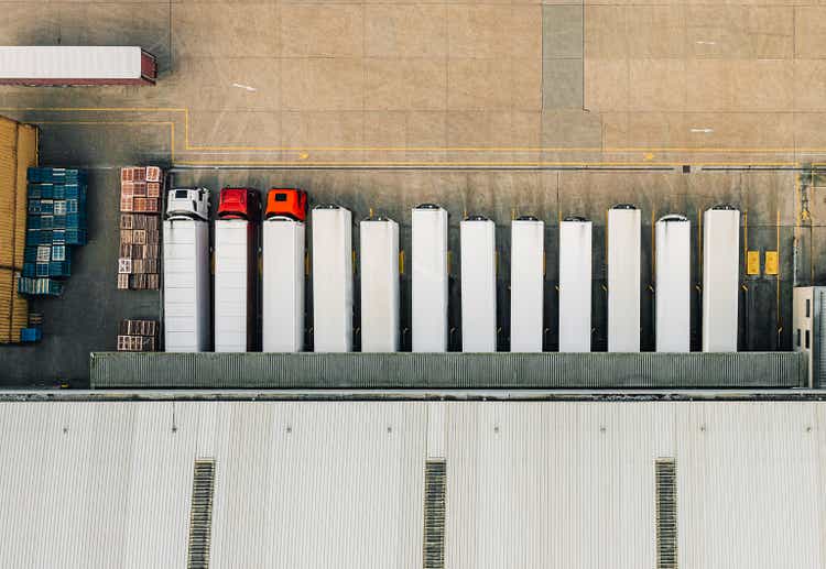 Drone view of a distribution warehouse with articulated lorries loading