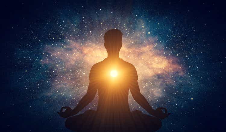 Man and soul. Yoga lotus pose meditation on nebula galaxy background