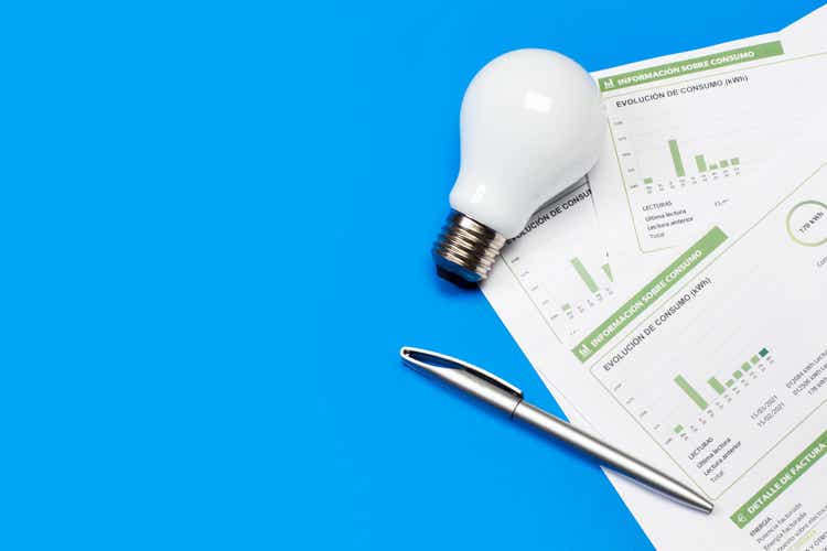 A lightbulb and an electricity bill on a blue background