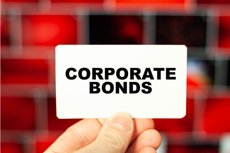 The concept of CORPORATE BONDS holds a businessman on a business card in his hand