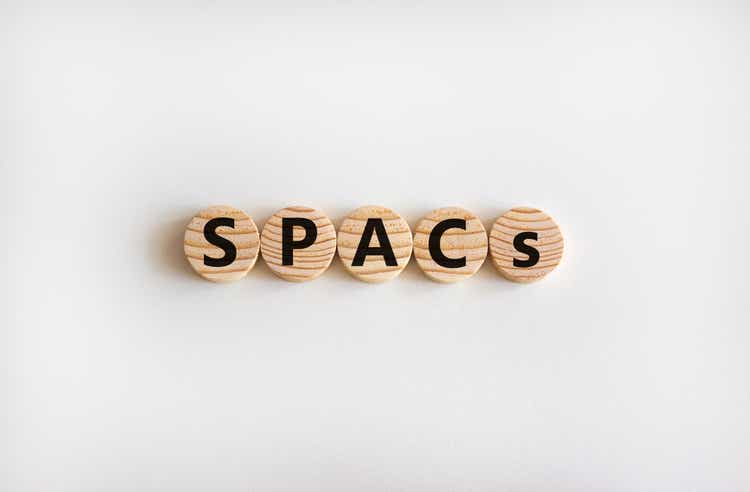 SPACs symbol. Wooden circles with words "SPACs, special purpose acquisition companies" on beautiful white background, copy space. Business and SPACs, special purpose acquisition companies concept.