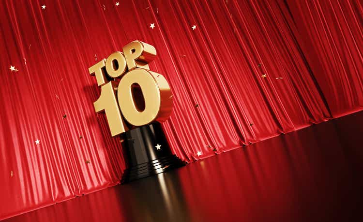 Top 10 Concept - Gold Colored Confetti Falling Onto A Gold Top 10 Award Sitting Before Red Stage Curtain
