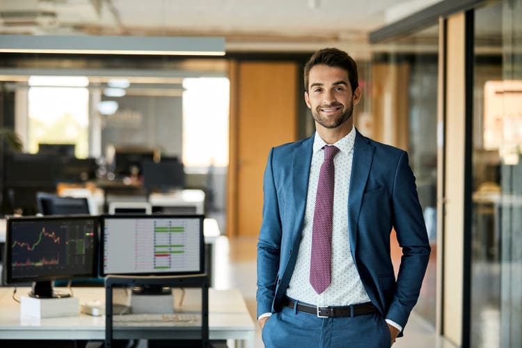 Happy Businessman With Hands In Pockets At Office