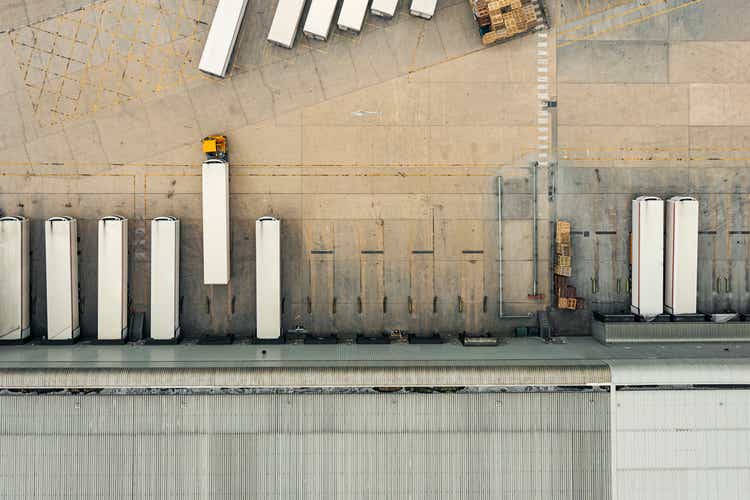 Drone view of a distribution warehouse with articulated lorries loading