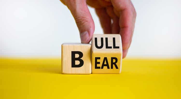 Symbol for a positive trend at the stock market. Businessman hand turns a cube and changes the word "bear" to "bull". Beautiful white background. Business and bear or bull concept. Copy space.