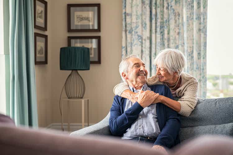 Senior couple hugging and having fun at home