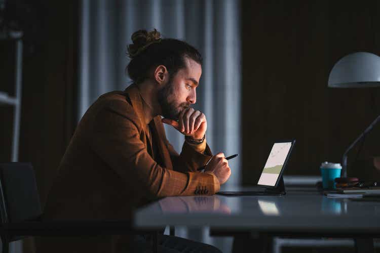 Pensive man working on laptop in office