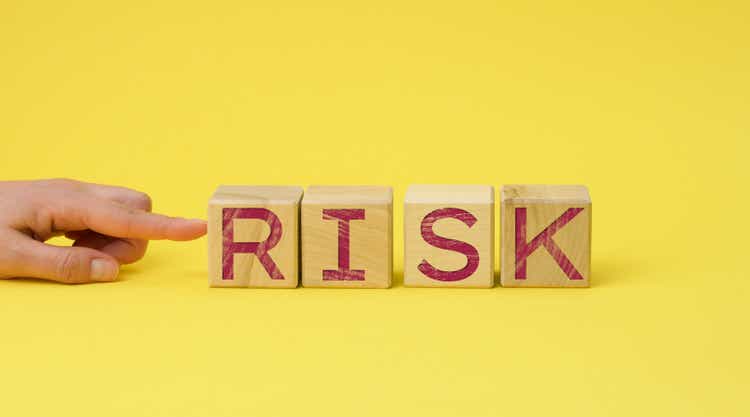 wooden cubes with the inscription risk on a yellow background. Risk reduction concept, reinsurance. How to avoid losses