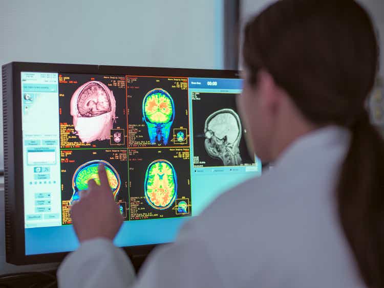 UK, North Yorkshire, Female doctor looking at MRI scanner monitor